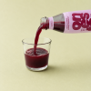 Granaatappelsap met gember en citroen wordt in een glas geschonken