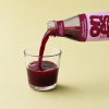 Granaatappelsap met aardbei en framboos wordt in een glas geschonken
