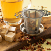 Glas limoncello spritz fruitthee met metalen theezeef en stukjes nougat