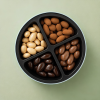 Open bewaarblik met vier compartimenten vol chocolade amandelen in verschillende smaken