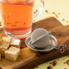 Royal Tea thee-ei met glas thee en nougat op houten plank