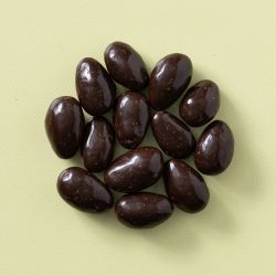 Pure chocolade amandelen in een rondje op een gele achtergrond