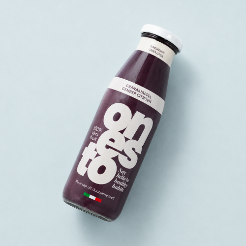 Fles granaatappelsap met gember en citroen 500 ml op lichtblauwe achtergrond Fles granaatappelsap met gember en citroen 500 ml op lichtblauwe achtergrond