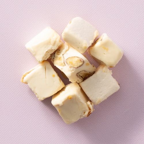 Soft nougat vanille met amandelen op een lichtroze achtergrond Soft nougat vanille met amandelen op een lichtroze achtergrond
