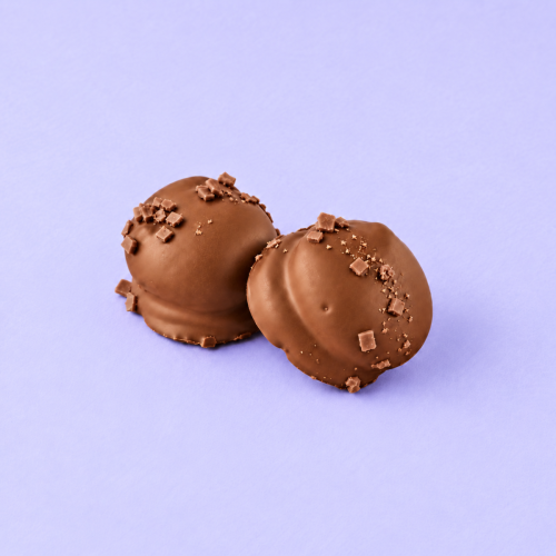 Chocolade mello cakes melk met krokante stukjes op lichtpaarse achtergrond Chocolade mello cakes melk met krokante stukjes op lichtpaarse achtergrond