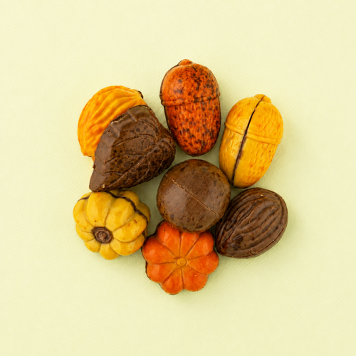 Herfst bonbons in verschillende vormen en kleuren op een lichtgele achtergrond Herfst bonbons in verschillende vormen en kleuren op een lichtgele achtergrond