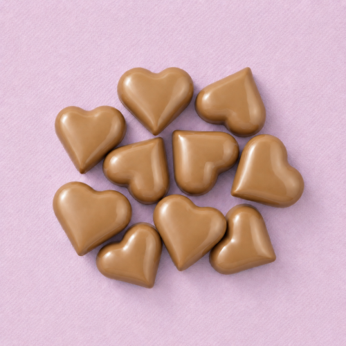 Chocolade hartjes karamel (9 stuks) op een lichtroze achtergrond Chocolade hartjes karamel (9 stuks) op een lichtroze achtergrond