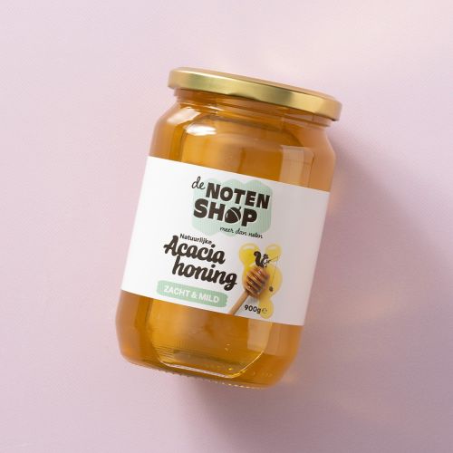 Pot acaciahoning op een lichtroze achtergrond Pot acaciahoning op een lichtroze achtergrond