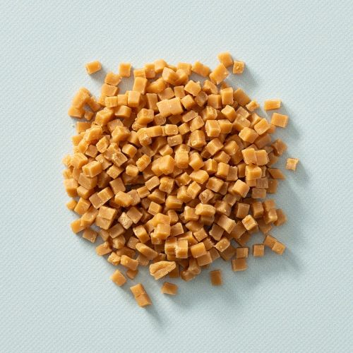 Mini karamelblokjes op een lichtblauwe achtergrond Mini karamelblokjes op een lichtblauwe achtergrond