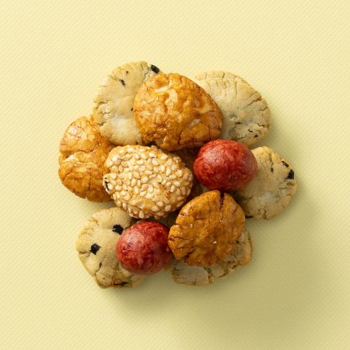 Kingbollen mix met verschillende krokante snacks en rode crackers op een lichtgele achtergrond Kingbollen mix met verschillende krokante snacks en rode crackers op een lichtgele achtergrond