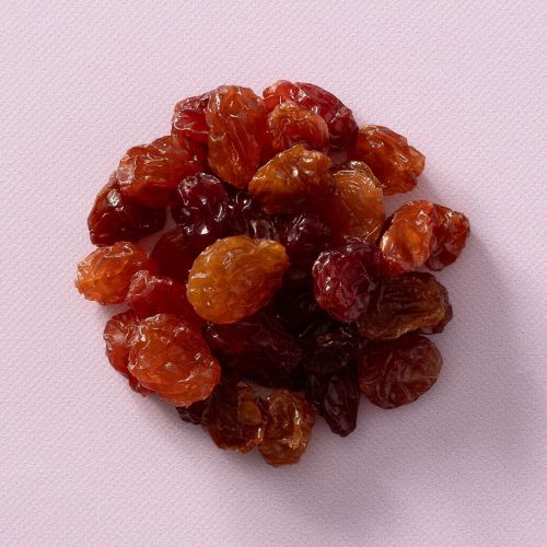 Rode crimson rozijnen op een lichtroze achtergrond Rode crimson rozijnen op een lichtroze achtergrond
