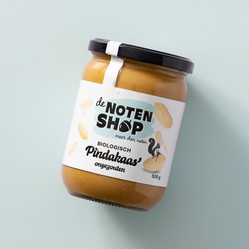 Pot pindakaas ongezouten, biologisch op een lichtblauwe achtergrond Pot pindakaas ongezouten, biologisch op een lichtblauwe achtergrond