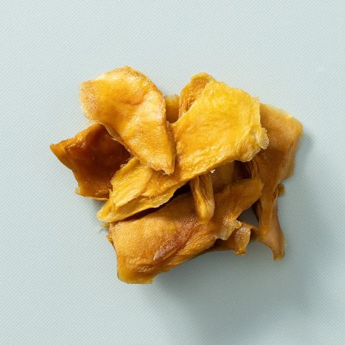 Gedroogde mango ongezoet en zacht op een lichtblauwe achtergrond
