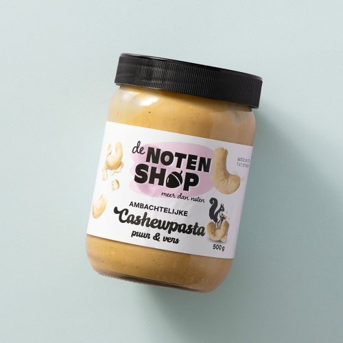 Pot ambachtelijke cashewpasta op een lichtblauwe achtergrond Pot ambachtelijke cashewpasta op een lichtblauwe achtergrond