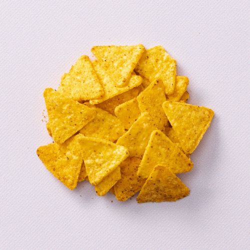Mini tortilla chips op een lichtpaarse achtergrond Mini tortilla chips op een lichtpaarse achtergrond