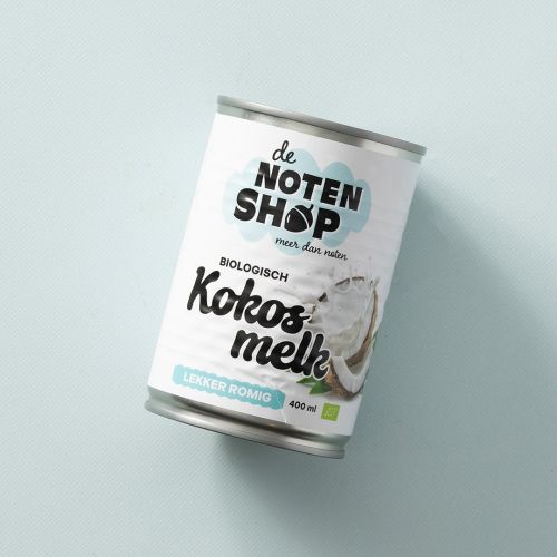 Blik biologische kokosmelk op een lichtblauwe achtergrond Blik biologische kokosmelk op een lichtblauwe achtergrond