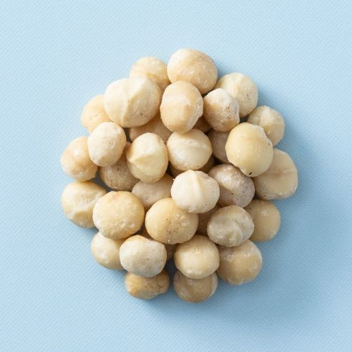 Macadamia noten ongebrand op een lichtblauwe achtergrond Macadamia noten ongebrand op een lichtblauwe achtergrond