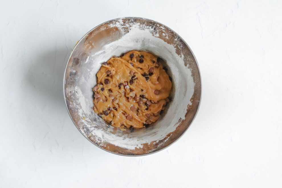 De chocolate chips gemengd door het beslag voor chocolate chip cookies.