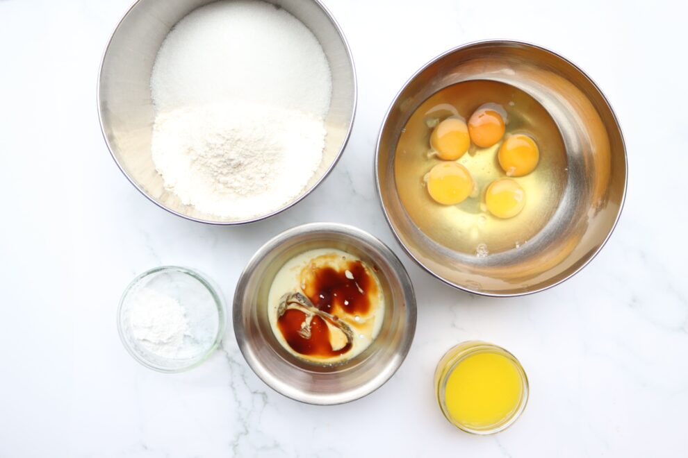 schalen met cake ingredienten, ei, bloem, suiker, vanillepasta, volle melk, zonnebloemolie, bakpoeder en zout