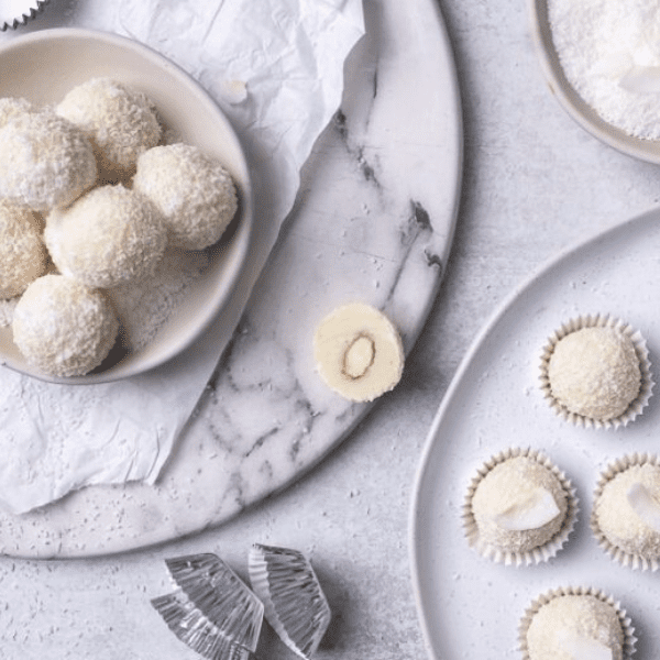 Sneeuwballen truffels van witte chocolade en kokos op een kerstbord.