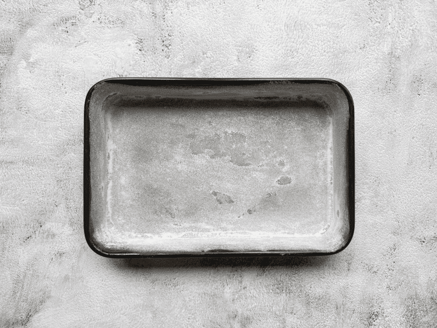 Een bakvorm voor sinaasappelcake ingevet