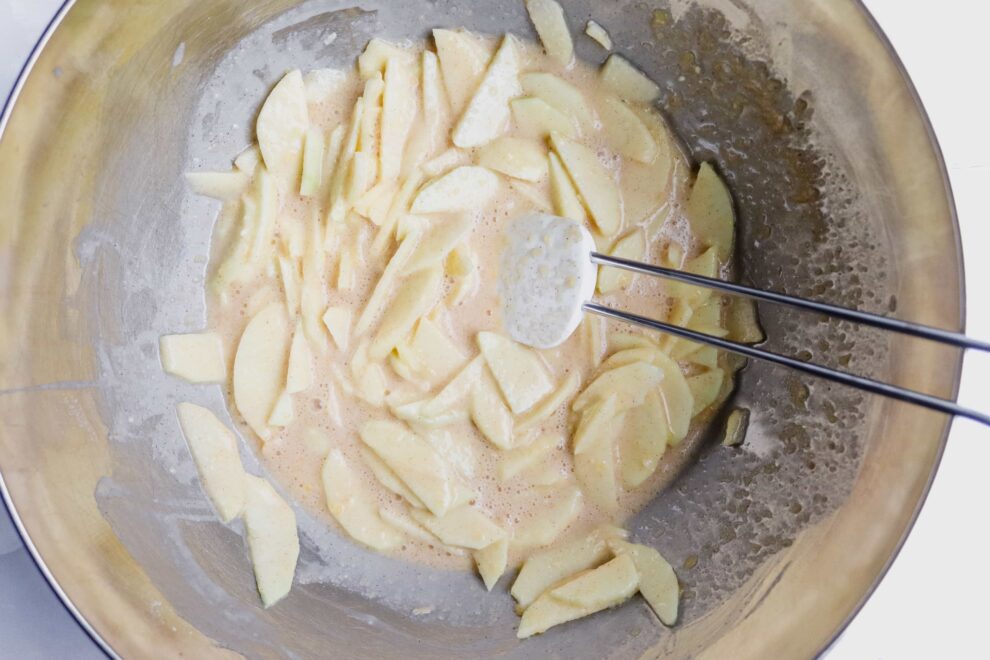 De dunne plakjes appel in het beslag voor de invisible appel cake